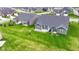 Aerial view of a beautiful backyard with a patio, lush green lawn, and well-maintained landscaping in a suburban neighborhood at 17066 Cole Evans Dr, Noblesville, IN 46060