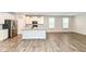 Open kitchen with white cabinets, stainless steel appliances, large island, and hardwood floors at 17066 Cole Evans Dr, Noblesville, IN 46060
