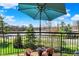 Outdoor balcony with blue umbrella and potted flowers, offering a scenic view of the surrounding landscape at 20971 Shoreline Ct # 306, Noblesville, IN 46062