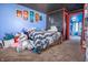 View of a bedroom with colorful blue walls, decorated with eye-catching artwork and cozy stuffed animals at 218 E Mechanic St, Shelbyville, IN 46176