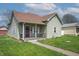 Exterior view of the charming home featuring a red front door and a quaint, covered porch at 218 E Mechanic St, Shelbyville, IN 46176