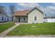 Charming home featuring a quaint covered porch, a red front door and a well-maintained front yard at 218 E Mechanic St, Shelbyville, IN 46176