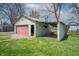 Image of the detached garage featuring a pink garage door and a shed roof extension at 218 E Mechanic St, Shelbyville, IN 46176