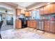 A kitchen showcasing oak cabinetry, stainless steel appliances, tile backsplash and flooring with a connected living room at 218 E Mechanic St, Shelbyville, IN 46176