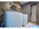 Laundry room featuring a modern white washer and dryer, storage shelving, and an exterior door at 218 E Mechanic St, Shelbyville, IN 46176