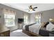 Bright bedroom features a ceiling fan, neutral colors, and natural light from large windows at 2225 Alabama St, Indianapolis, IN 46205