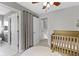 Cozy Bedroom features neutral decor, a ceiling fan, and a classic wooden crib on plush rug at 2225 Alabama St, Indianapolis, IN 46205
