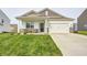 Inviting single-story home featuring a well-maintained lawn, a two-car garage, and lovely curb appeal at 238 Switchgrass Ln, New Whiteland, IN 46184