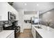 Modern kitchen with stainless steel appliances, white cabinets, and a center island with a sink at 238 Switchgrass Ln, New Whiteland, IN 46184