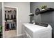 Functional laundry room featuring modern white washer and dryer with adjacent closet for extra storage at 238 Switchgrass Ln, New Whiteland, IN 46184