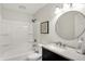 Bright bathroom features a black vanity, white tile and a shower-tub combo at 2404 Wildwood Ave, Anderson, IN 46011