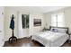 Bright bedroom with hardwood floors, two windows, white curtains, and a comfortable queen-size bed at 2404 Wildwood Ave, Anderson, IN 46011