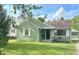 Charming one-story home with green siding, a well-manicured lawn, and beautiful landscaping at 2404 Wildwood Ave, Anderson, IN 46011