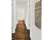 Hallway with hardwood floors and white trim, leading to a bathroom and other rooms at 2404 Wildwood Ave, Anderson, IN 46011