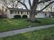 Well-manicured front yard with lawn and flower bed accentuates this ranch style home at 2465 N Eaton Ave, Indianapolis, IN 46219