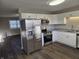 Updated kitchen features modern stainless steel appliances, white cabinetry, and granite countertops at 2465 N Eaton Ave, Indianapolis, IN 46219