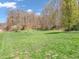 Expansive backyard with lush green grass, trees, and a storage shed in the distance at 257 N Letterman Rd, Paragon, IN 46166