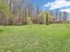 Spacious grassy backyard with mature trees and a charming brick home on a slight rise at 257 N Letterman Rd, Paragon, IN 46166