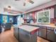 Kitchen with island, wooden floors, and stainless sink adjoining a living room at 257 N Letterman Rd, Paragon, IN 46166