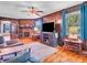 Inviting living room with a brick fireplace, wood paneling, hardwood floors, and a TV, creating a comfortable and relaxing space at 257 N Letterman Rd, Paragon, IN 46166