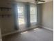 Neutral bedroom with gray carpet features two windows with light-filtering blue curtains and shelving at 302 Sanders St, Indianapolis, IN 46225