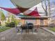 Backyard patio with colorful sunshades, table and chairs, brick garage and manicured backyard at 3128 E Fall Creek Pkwy N Dr, Indianapolis, IN 46205