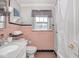 This vintage bathroom features salmon-colored tile, a window, and bathtub at 3128 E Fall Creek Pkwy N Dr, Indianapolis, IN 46205