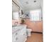 Salmon tiled bathroom featuring vanity with marble countertop, lighting, and vintage tile flooring at 3128 E Fall Creek Pkwy N Dr, Indianapolis, IN 46205