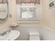 Bathroom featuring a pedestal sink, wainscoting, and a window with shutter at 3128 E Fall Creek Pkwy N Dr, Indianapolis, IN 46205