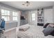 Neutral bedroom featuring bright windows, bookshelf, and a comfortable workspace at 3128 E Fall Creek Pkwy N Dr, Indianapolis, IN 46205