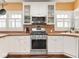 Kitchen with stainless steel appliances, white cabinets, and tile backsplash at 3128 E Fall Creek Pkwy N Dr, Indianapolis, IN 46205