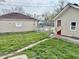 View of the backyard showing the detached garage and shed, plus scattered weeds at 3136 Foltz St, Indianapolis, IN 46221