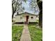 Charming home featuring a red door, white trim, walkway, and a well-maintained yard at 3136 Foltz St, Indianapolis, IN 46221