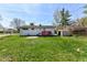 Well-maintained backyard with lush lawn, shed, and a cozy red deck, perfect for outdoor living at 319 E Ohio St, Fortville, IN 46040