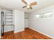 Bedroom with hardwood floors, a ceiling fan, closet shelving and a window with natural light at 319 E Ohio St, Fortville, IN 46040