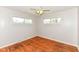 A bright bedroom with hardwood floors, ceiling fan, and two windows providing plenty of natural light at 319 E Ohio St, Fortville, IN 46040