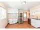Bright kitchen with white cabinets, stainless steel fridge, wood-look floors, and natural light at 319 E Ohio St, Fortville, IN 46040