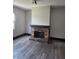 Living room with a brick fireplace, baseboard trim and wood-look flooring at 325 Harlan St, Indianapolis, IN 46201