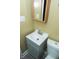 The bathroom features a modern sink with an oak framed mirror and white toilet at 3601 N Kenwood Ave, Indianapolis, IN 46208