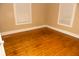 A neutral bedroom with wood floors, two windows, and simple white trim at 3601 N Kenwood Ave, Indianapolis, IN 46208