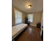Bedroom with light walls, two windows, hardwood floors, and shoe rack at 3601 N Kenwood Ave, Indianapolis, IN 46208
