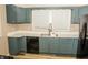 Well-lit kitchen featuring blue cabinets, sleek countertops, and modern appliances at 3601 N Kenwood Ave, Indianapolis, IN 46208