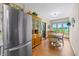 Bright dining area features a wood table, china cabinet, and stainless refrigerator, with a backyard view at 403 N Red Gold Dr, Trafalgar, IN 46181