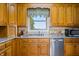 Well-lit kitchen features classic wood cabinets, stainless steel appliances, and granite countertops at 403 N Red Gold Dr, Trafalgar, IN 46181
