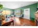 Inviting living room boasts hardwood floors, natural light from multiple windows, and calming green walls at 403 N Red Gold Dr, Trafalgar, IN 46181