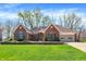 Beautiful red brick home with well-manicured lawn and blooming flower beds in a suburban setting at 424 Orchard Blvd, Danville, IN 46122