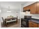 A kitchen and dining area featuring brown wooden cabinets and modern appliances at 4464 Four Seasons Cir, Indianapolis, IN 46226