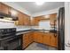 Well-lit kitchen featuring wooden cabinets, black appliances, and modern countertops at 4464 Four Seasons Cir, Indianapolis, IN 46226