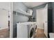 Convenient laundry room with modern washer and dryer, complemented by ample shelving for organized storage solutions at 4464 Four Seasons Cir, Indianapolis, IN 46226