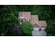 Aerial view of a brick home with mature trees, attached garage, and manicured lawns showcasing its beautiful neighborhood at 4541 Greenthread Ct, Zionsville, IN 46077